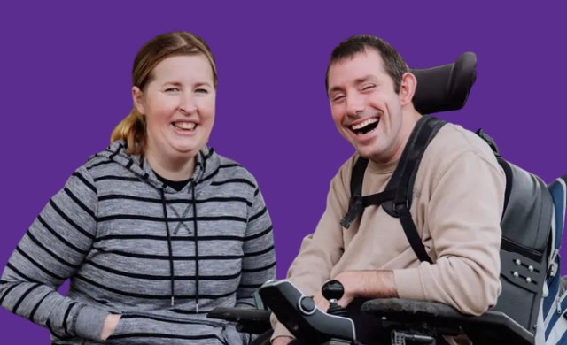 Two NDIS participants smiling together, one using a powered wheelchair